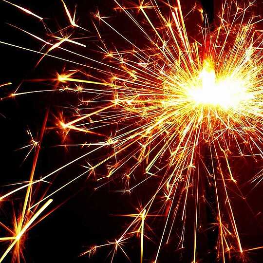 Sekt an Silvester - Hotel Munte am Stadtwald - Bremen Eine Wunderkerze sprüht helle, gelbe Funken in alle Richtungen.